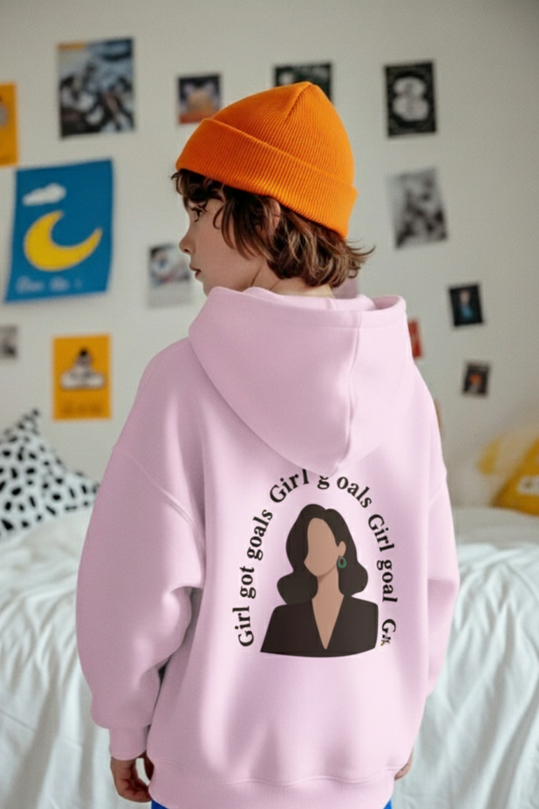 Person wearing a pink hoodie with a graphic design in a bedroom setting